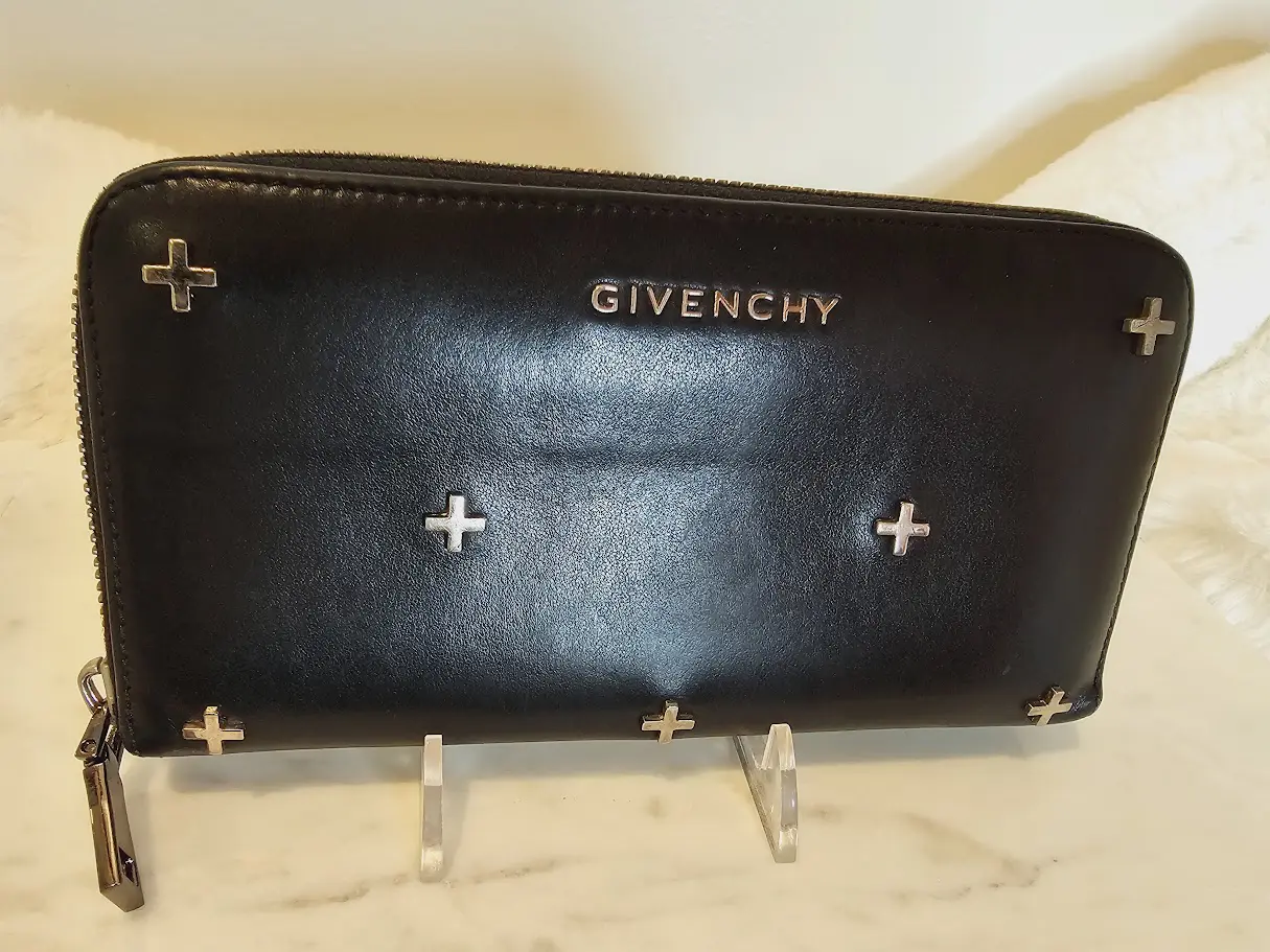 A black purse with silver crosses on it.