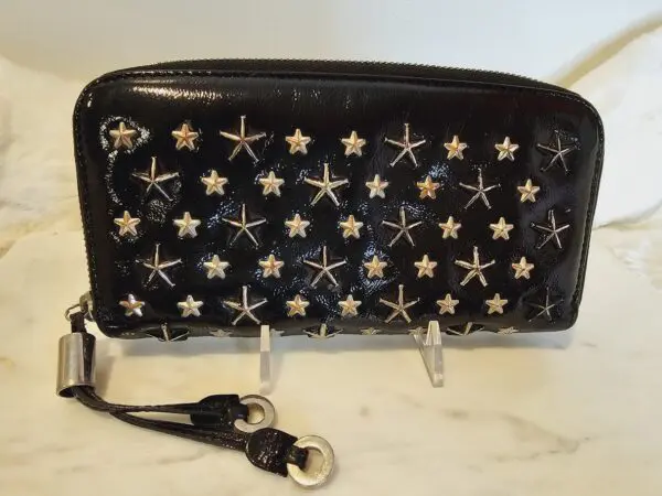 A black purse with silver stars on it.