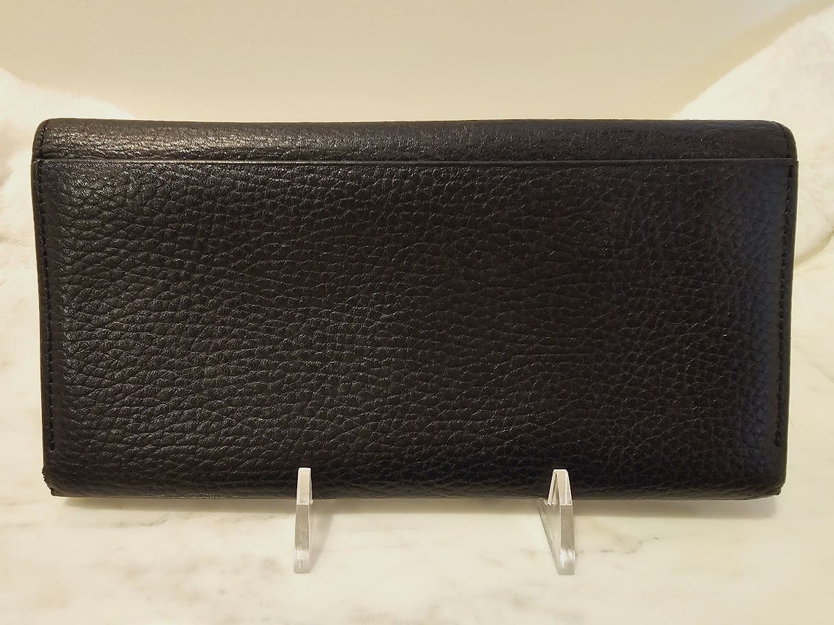 A black leather wallet sitting on top of a counter.