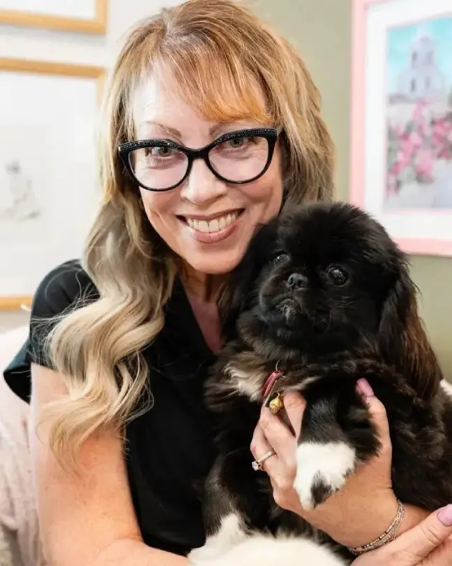 A woman holding a dog in her arms.