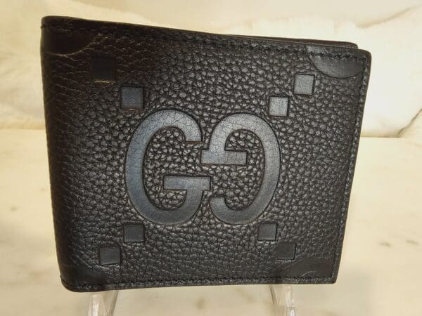 A black wallet with the letter g on it.