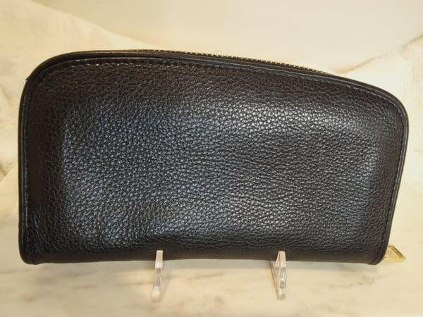 A black leather purse sitting on top of a table.